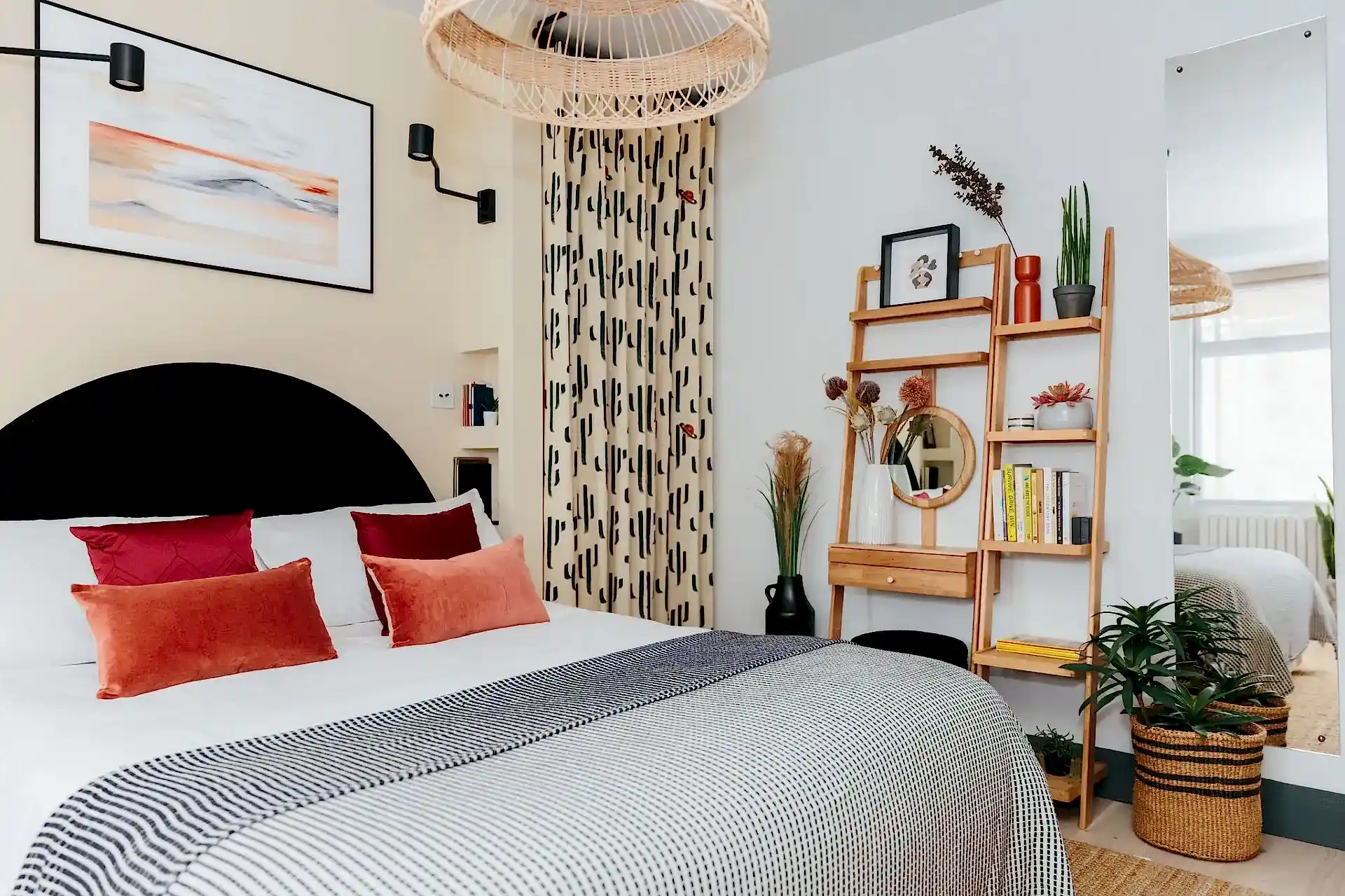 Modern warm neutral bedroom with pops of burnt red