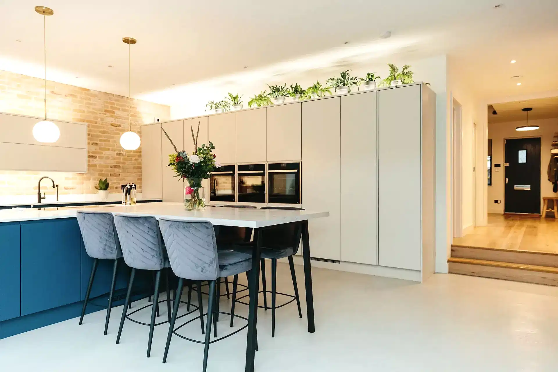 modern open blue and white kitchen with exposed brick