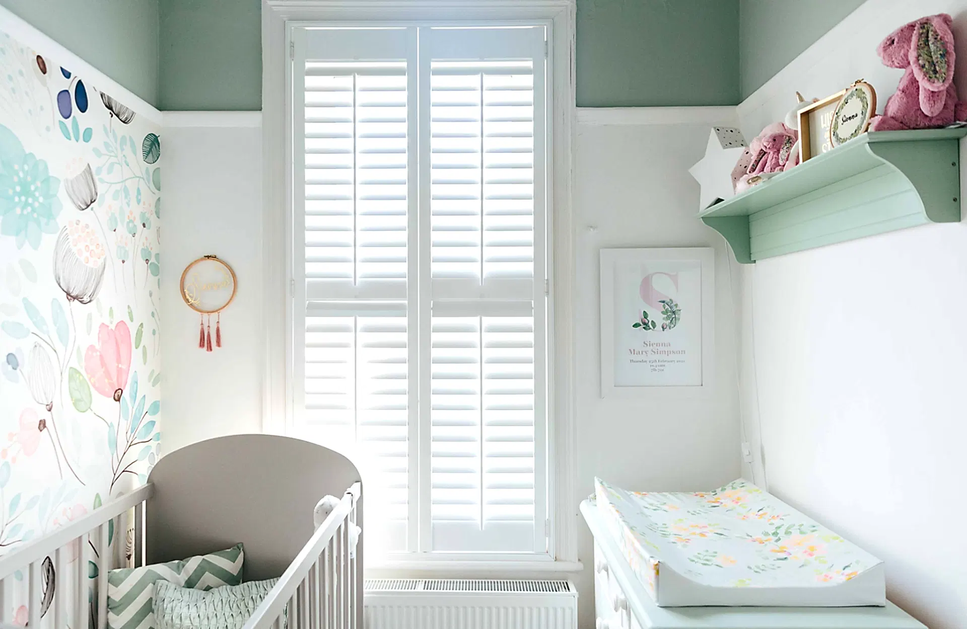 green nursery with floral wallpaper